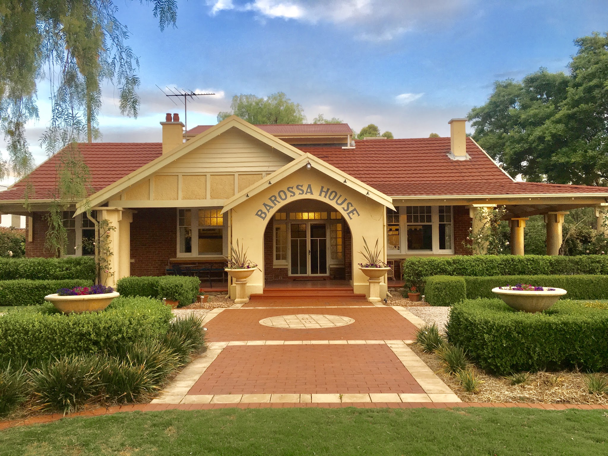 Barossa House seen from the front lawn, with the brick path leading up to the entrance arch